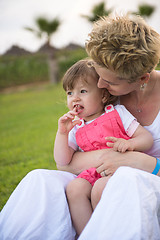 Image showing mother and little daughter playing at backyard