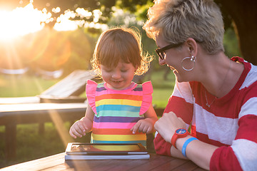 Image showing mom and her little daughter using tablet computer