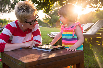 Image showing mom and her little daughter using tablet computer