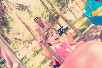 Image showing mother and daughter swinging in the park