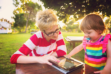 Image showing mom and her little daughter using tablet computer