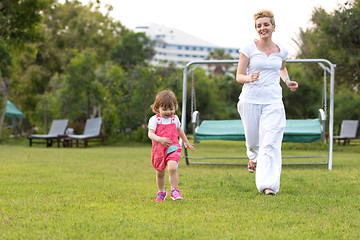 Image showing mother and little daughter playing at backyard