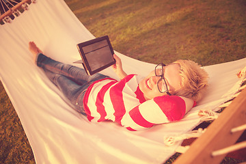 Image showing woman using a tablet computer while relaxing on hammock