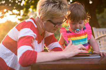 Image showing mom and her little daughter using tablet computer