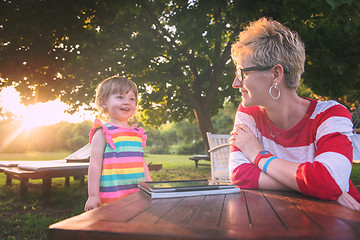 Image showing mom and her little daughter using tablet computer