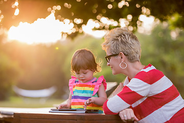 Image showing mom and her little daughter using tablet computer