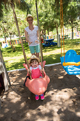 Image showing mother and daughter swinging in the park