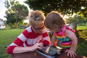 Image showing mom and her little daughter using tablet computer