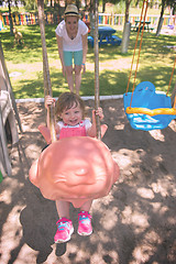 Image showing mother and daughter swinging in the park