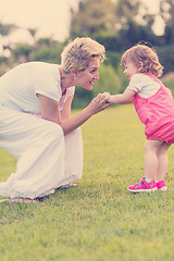 Image showing mother and little daughter playing at backyard