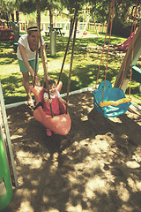 Image showing mother and daughter swinging in the park