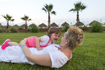 Image showing mother and little daughter playing at backyard