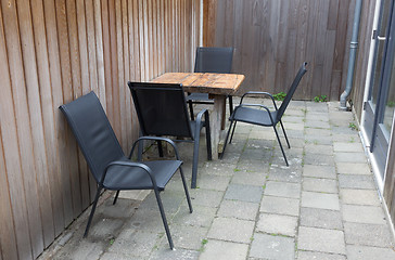 Image showing Table and chairs In small stone garden