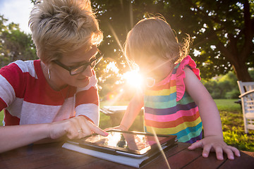 Image showing mom and her little daughter using tablet computer