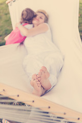 Image showing mother and a little daughter relaxing in a hammock