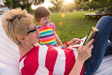 Image showing mom and a little daughter relaxing in a hammock