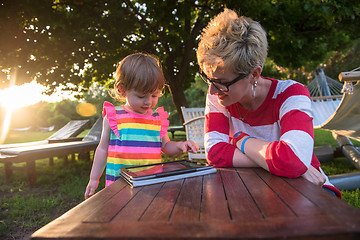 Image showing mom and her little daughter using tablet computer