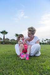 Image showing mother and little daughter playing at backyard