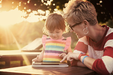 Image showing mom and her little daughter using tablet computer