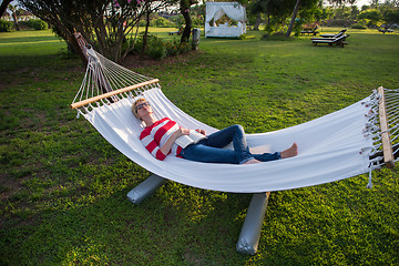 Image showing woman reading a book while relaxing on hammock