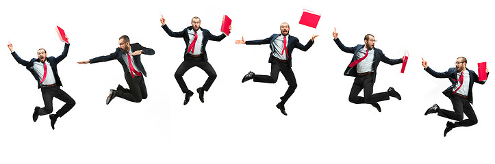 Image showing Funny cheerful businessman jumping in air over white background
