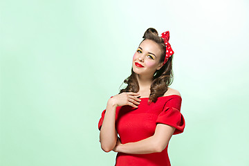 Image showing Beautiful young woman with pinup make-up and hairstyle. Studio shot on white background