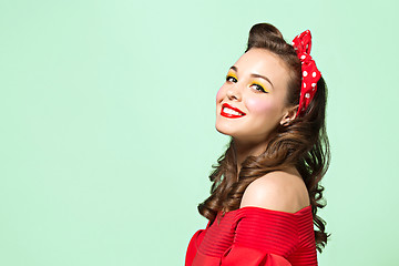 Image showing Beautiful young woman with pinup make-up and hairstyle. Studio shot on white background