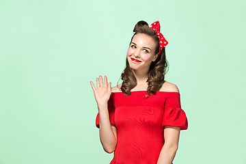 Image showing Beautiful young woman with pinup make-up and hairstyle. Studio shot on white background