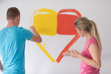 Image showing couple are painting a heart on the wall