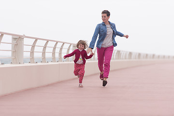 Image showing mother and cute little girl on the promenade by the sea