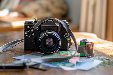 Image showing Old photo film roll and retro camera on desk.