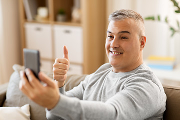 Image showing man having video chat on smartphone at home