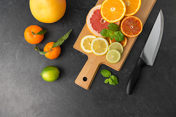 Image showing close up of fruits and knife on slate table top