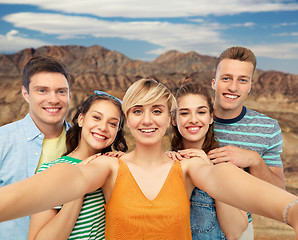 Image showing happy friends taking selfie over grand canyon