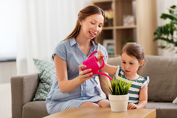 Image showing pregnant mother and daughter watering home plant