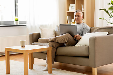 Image showing man with laptop computer sitting on sofa at home