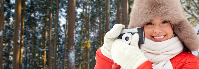 Image showing happy woman with film camera over winter forest