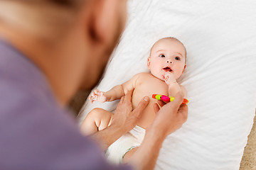 Image showing close up of father and baby with rattle toy