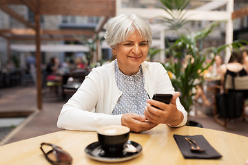 Image showing happy senior woman with smartphone at street cafe