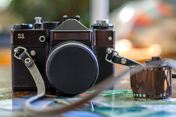 Image showing Old photo film roll and retro camera on desk