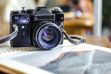 Image showing Retro photo camera, film and old photo album on the table