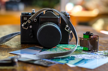 Image showing Old photo film roll and retro camera on desk.