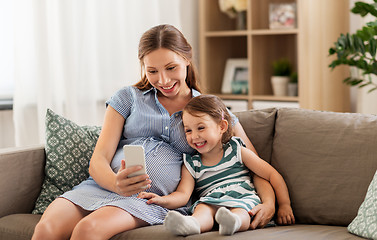 Image showing pregnant mother and daughter with smartphone