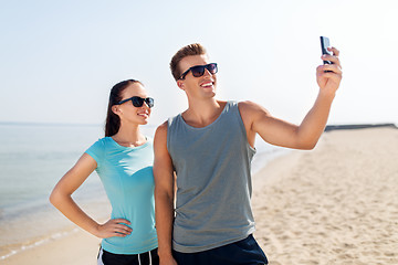 Image showing couple taking selfie by smartphone on beach