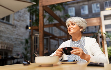 Image showing senior woman drinking coffee at street cafe