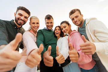 Image showing happy friends showing thumbs up