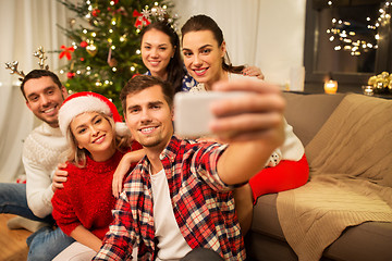 Image showing friends celebrating christmas and taking selfie