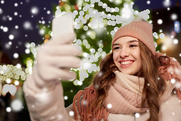 Image showing young woman taking selfie over christmas tree