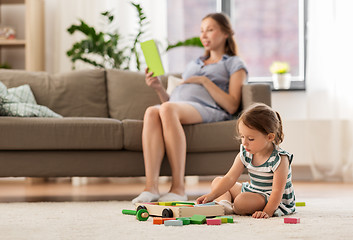 Image showing happy baby girl playing with toy blocks at home