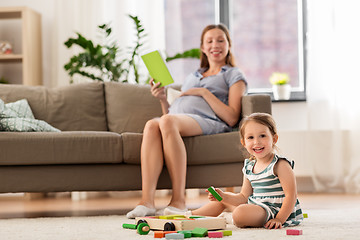 Image showing happy baby girl playing with toy blocks at home